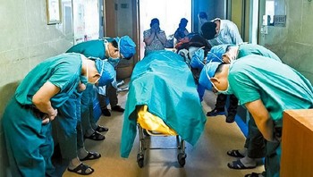 Kumpulan dokter saling membungkuk memberi penghormatan terakhir di depan jenazah anak laki-laki Tionghoa berusia 11 tahun yang didiagnosis mengidap kanker. Pasalnya anak ini memberikan organ-organ tubuhnya untuk menyelamatkan pasien lain.  (Foto: Brightside)