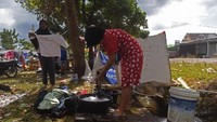 Seorang pengungsi korban gempa bumi mencuci pakaian mengunakan air dari parit di dekat tempat pengungsian di Desa Santong, Kayangan, Lombok Utara, NTB, Sabtu (11/8). ANTARA FOTO/Zabur Karuru.