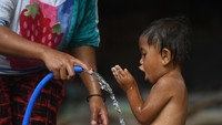 Seorang ibu memandikan anaknya di tempat pengungsian korban gempa bumi di Desa Santong, Kayangan, Lombok Utara, NTB, Sabtu (11/8). ANTARA FOTO/Zabur Karuru.