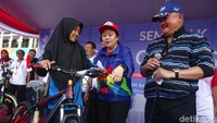 Puan Maharani dan Alex Noerdin menyerahkan hadiah sepeda kepada seorang siswi di kota Palembang.