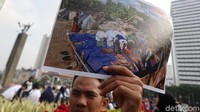 Seorang relawan menunjukkan foto warga korban gempa yang sedang salat di lokasi pengungsian.