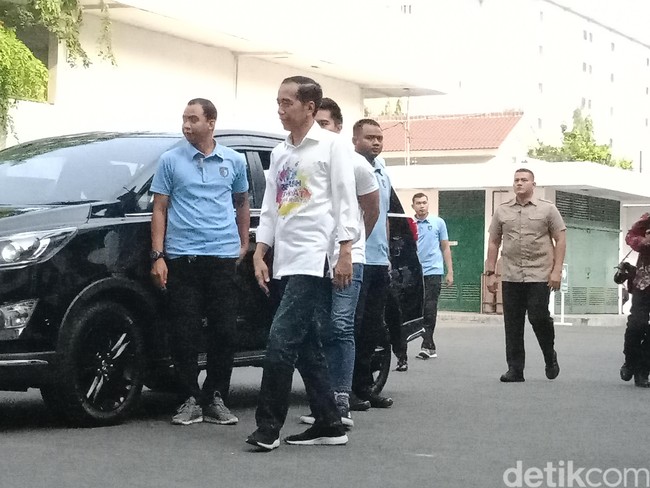 Jokowi kembali tampil memakai sneakers dari NAH Project dengan kemeja bertuliskan Bersih, Merakyat, Kerja Nyata dan celana jeans. Sebelumnya, ia memakai sepatu berseri FlexiKnit v2.0 itu ketika menghadiri festival musik We The Fest 2018 dan pertemuan dengan sembilan Sekjen Parpol. Foto: Niken Purnamasari/detikcom