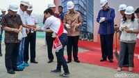 Chairul Tanjung (CT) memakai sarung tangan sebelum melakukan prosesi tutup atap (topping off).