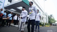 Jokowi mengenakan kemeja putih bertuliskan Bersih, Merakyat, Kerja Nyata dengan corak warna-warni.