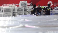 Para pekerja membongkar paket berisi beralatan tanding angkat besi.