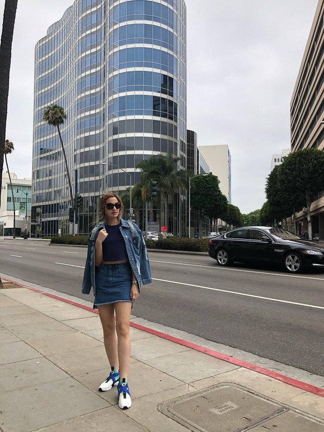 Nia Ramadhani dengan setelan jaket dan rok mini denim serta crop top, berpose dengan gaya baby giraffe. Tubuhnya yang sudah cukup tinggi jadi terlihat semakin jenjang dan ramping. Foto: Instagram