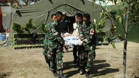 Beberapa prajurit TNI menggotong warga yang mengalami patah tulang leher menggunakan tandu menuju helikopter. Istimewa/Puspen TNI.