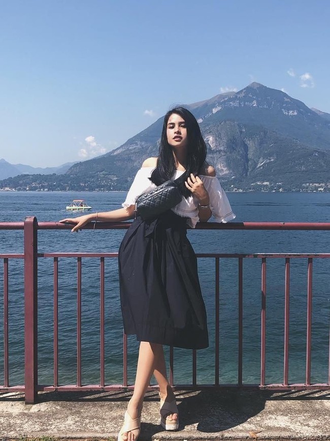 Maudy Ayunda pun tak ketinggalan bergaya baby giraffe pose. Memakai rok selutut, ia tampak menyilangkan kaki kirinya untuk memberi ilusi tubuh yang lebih ramping. Foto: Instagram