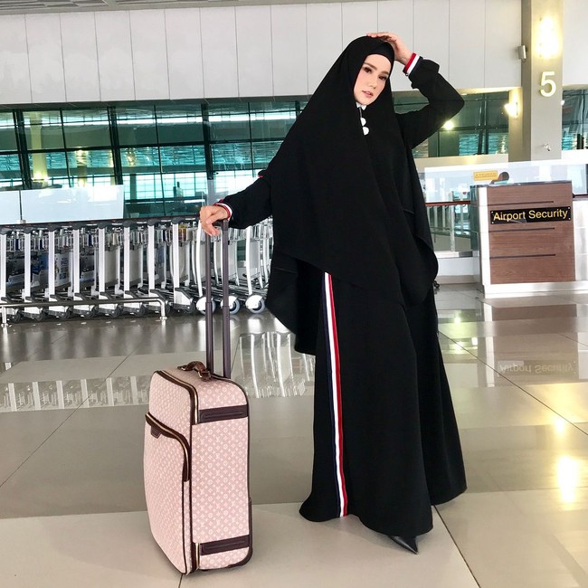 Mulan Jameela juga memakai hijab syari saat bepergian. Ia terlihat memakai gamis dan khimar panjang berwarna hitam. Satu set khimar dan gamis itu dibandrol seharga Rp 475.000.  Foto: Instagram/MulanJameela1