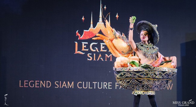 Biw Nantapak Kraiha rupanya memakai gaun berbentuk mangkuk tomyam, makanan khas Thailand. Terlihat udang palsu berukuran raksasa ikut menjadi hiasan dari busananya. Foto: Facebook Miss Grand Thailand