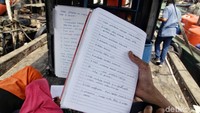 Salah seorang murid menunjukkan catatan yang ditulisnya selama belajar. Para guru pun tak hanya menunggu para murid datang untuk belajar, tak jarang mereka juga mengajak langsung beberapa anak di wilayah itu untuk sekolah karena kepedulian mereka agar anak-anak tersebut tak putus sekolah.