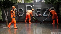 Usai dibersihkan, petugas PPSU lalu mengeringkan trotoar.