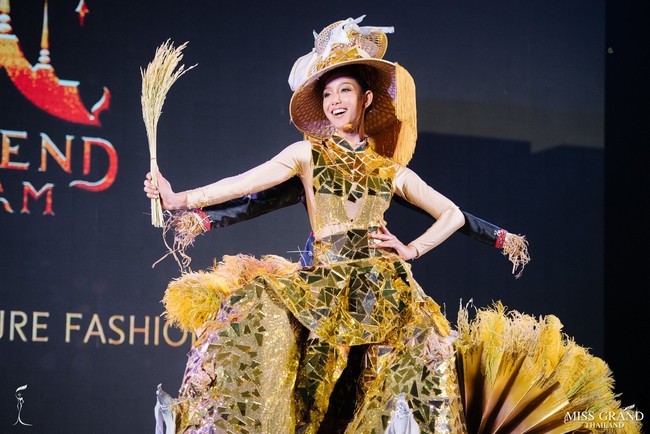 Tapi penampilan Rattikorn berubah jadi unik saat bagian rok gaunnya terbuka. Tampak bagian rok tersebut dihiasi tanaman padi buatan. Dan punggung wanita cantik ini juga dilengkapi boneka orang-orangan sawah. Foto: Facebook Miss Grand Thailand