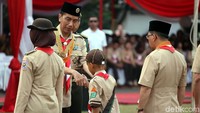 Jokowi memberikan penghargaan kepada perwakilan anggota pramuka.