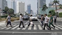 Sejumlah warga sedang menyeberang di Pelican Cross. Tampak petugas lalu lintas bersiaga di jalur Pelican Cross untuk membantu masyarakat menyeberang.