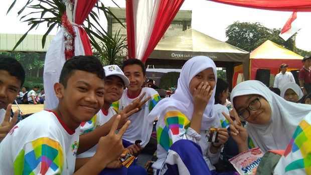 Sejumlah siswa SMP ikut memeriahkan kedatangan api obor dengan membawa bendera peserta Asian Games