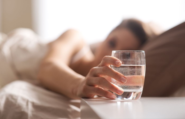 Close up of womans hand taking a glass of water