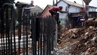 Petugas bergotong-royong menyelesaikan pekerjaan.