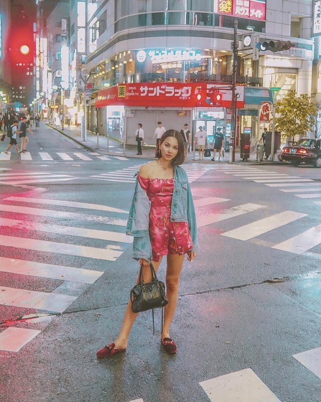 Berpose di kawasan Shinjuku, Jepang, Alyssa Daguise memadukan busana berbahan satin dengan jaket denim. Dia juga terlihat menenteng tas Balenciaga dan memakai sepatu mules Gucci. Foto: Instagram Alyssa Daguise