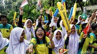 Wajah antusias dan penuh semangat anak-anak sekolah menyambut pawai obor Asian Games.