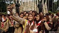 Beberapa anggota pramuka asyik berswafoto bersama.