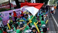 Membawa serta bendera peserta Asian Games 2018, salah seorang anak mengibarkan bendera merah putih untuk merayakan HUT RI ke-73.
