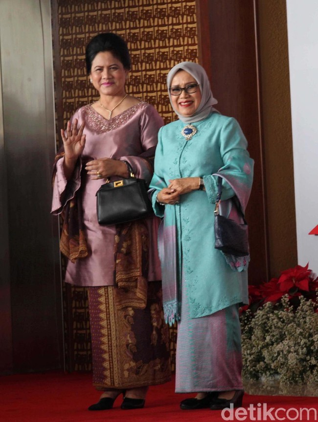 Iriana Jokowi muncul dalam balutan kebaya keunguan bermodel baju kurung yang dipadu dengan bawahan berupa kain batik dan selendang senada. Tidak ketinggalan, tas tangan berwarna hitam ikut memaksimalkan gayanya. (Foto: Lamhot Aritonang)