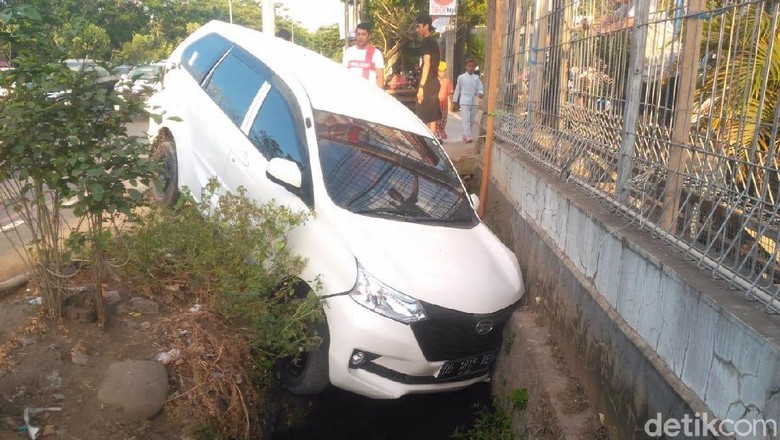 Mobil yang nyungsep ke selokan Foto: Ibnu Munsir Mobil yang nyungsep ke selokan Foto: Ibnu Munsir