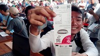 Senyum semringah salah satu pengunjung yang telah berhasil menukar tiket opening Asian Games 2018 usai mengantre panjang.