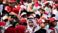 Meskipun harus berpanas-panasan, anak-anak itu tampak semangat dan tak sabar mengibarkan bendera untuk menyambut pawai obor Asian Games 2018.