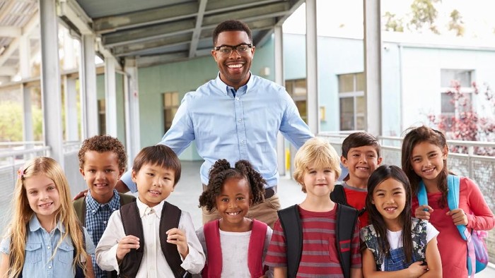 Portrait of elementary school kids and teacher in corridor