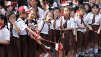 Anak-anak berbaris di pinggir jalan.