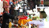 Presiden Jokowi menyerahkan bendera merah putih untuk dikibarkan.