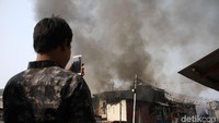 Seorang warga mengabadikan kebakaran menggunakan smartphone.