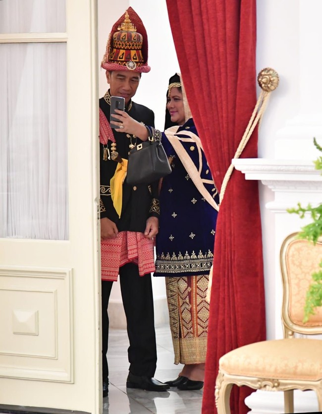 Kekhasan lainnya dari busana adat Koto Gadang adalah baju kuruang atau kurung berbahan beludru yang dipadukan dengan kain songket. Iriana Jokowi memadukan baju tersebut dipadukan dengan selendang yang senada dengan kain songketnya. Foto: Laily Rachev/Biro Pers Setpres