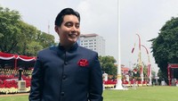 Edric Tjandra memang tak berkebaya, namun ia tampil gagah berpose dengan latar belakang bendera Merah Putih Foto: (dok. Instagram)