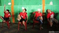 Dalam lomba ini, satu ujung tali diikatkan di kerupuk dan ujung yang satunya lagi diikatkan di jempol kaki.