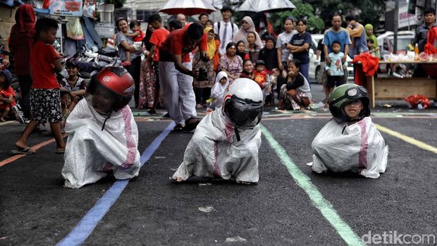 Lomba balap karung pakai helm memeriahkan HUT ke-73 RI di kawasan Pasar Minggu, Jakarta Selatan, Jumat (17/8/2019). Meski sulit, para peserta tetap antusias mengikuti perlombaan.