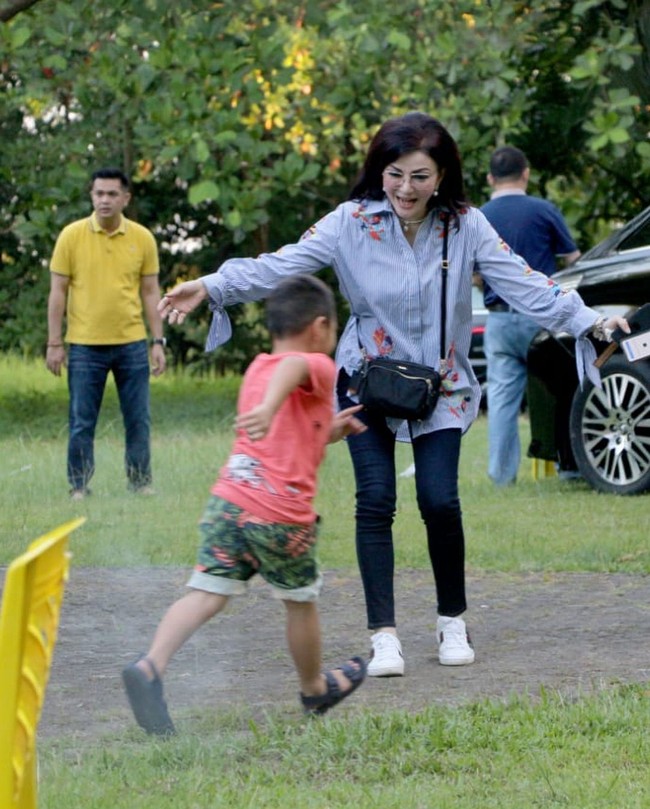 Sepatu sneakers Gucci tampak melengkapi gaya casual Bupati Tetty saat bermain bersama anak-anak. Bupati yang satu ini pun pernah mendapat gelar Best Dressed Woman dari Lions Club International. Foto: Dok. Instagram Christiany E. Tetty Paruntu