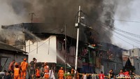 Warga sekitar turut membantu memadamkan api.