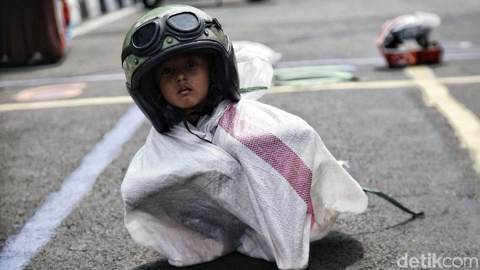 Lomba balap karung pakai helm memeriahkan HUT ke-73 RI di kawasan Pasar Minggu, Jakarta Selatan, Jumat (17/8/2019). Meski sulit, para peserta tetap antusias mengikuti perlombaan.