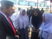  Aisyah (kanan) berbincang menggunakan bahasa isyarat dengan Wahyudi didampingi pendamping (kerudung hitam).