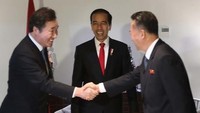 Pemimpin Korea Selatan dan Korea Utara saling berjabat tangan di hadapan Jokowi sebelum pembukaan Asian Games 2018 dimulai. Foto: dok. Yonhap