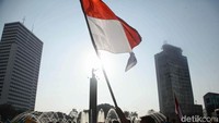 Salah seorang pengunjung mengibarkan bendera merah putih untuk memperingati Hari Kemerdekaan Indonesia yang ke-73 tahun.