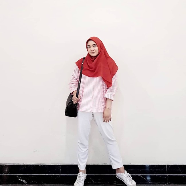 Selebgram dan blogger Suci Utami tampil kasual dengan kemeja bergaris. Hijab segi empat berwarna merah dan celana putih menyempurnakan tampilan kasualnya. (Foto: Instagram)