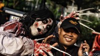 Salah seorang warga berfoto bersama makhluk seram.
