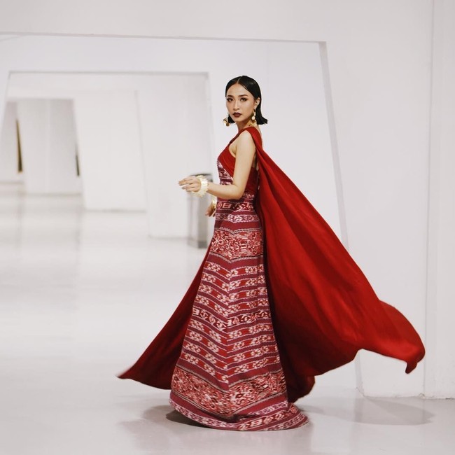 Rinni Wulandari memesona dengan gaun tenun merah yang dilengkapi jubah panjang. (Foto: Instagram)