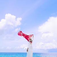 Berfoto di pantai Maldives, Dian Pelangi tampak elegan mengenakan dress berwarna putih. Ia mengenakan hijab motif bernuansa merah dan mengibarkan scarf bernuansa merah putih. (Foto: Instagram)