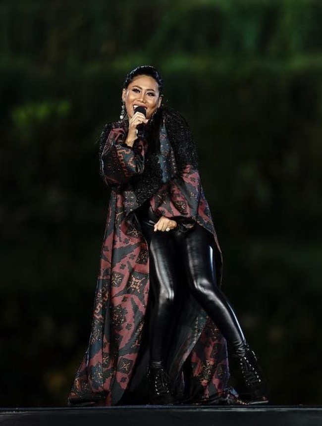 Busana rancangan Ivan Gunawan yang berhiaskan motif tenun gringsing menjadi pilihan pedangdut Evi Masamba. Busana tersebut hadir dengan celana kulit dan coat panjang berekor nan dramatis yang menyapu lantai. (Foto: Getty Images)
