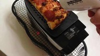 Kesal pizzanya sudah dingin, pria ini hangatkan pizza di atas setrika diikuti angin hangat dari pengering rambut. Foto: Istimewa